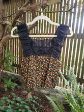 Load image into Gallery viewer, Black lace top and floral skirt on a hanger against a natural background
